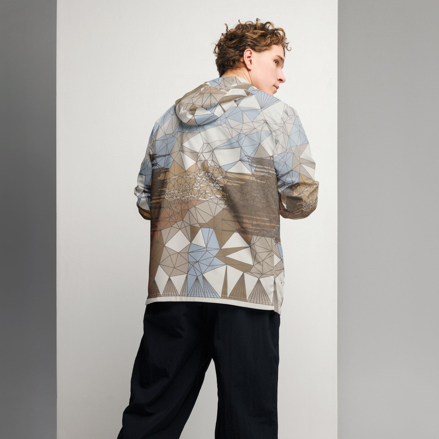Person wearing an abstract patterned windbreaker against a plain background