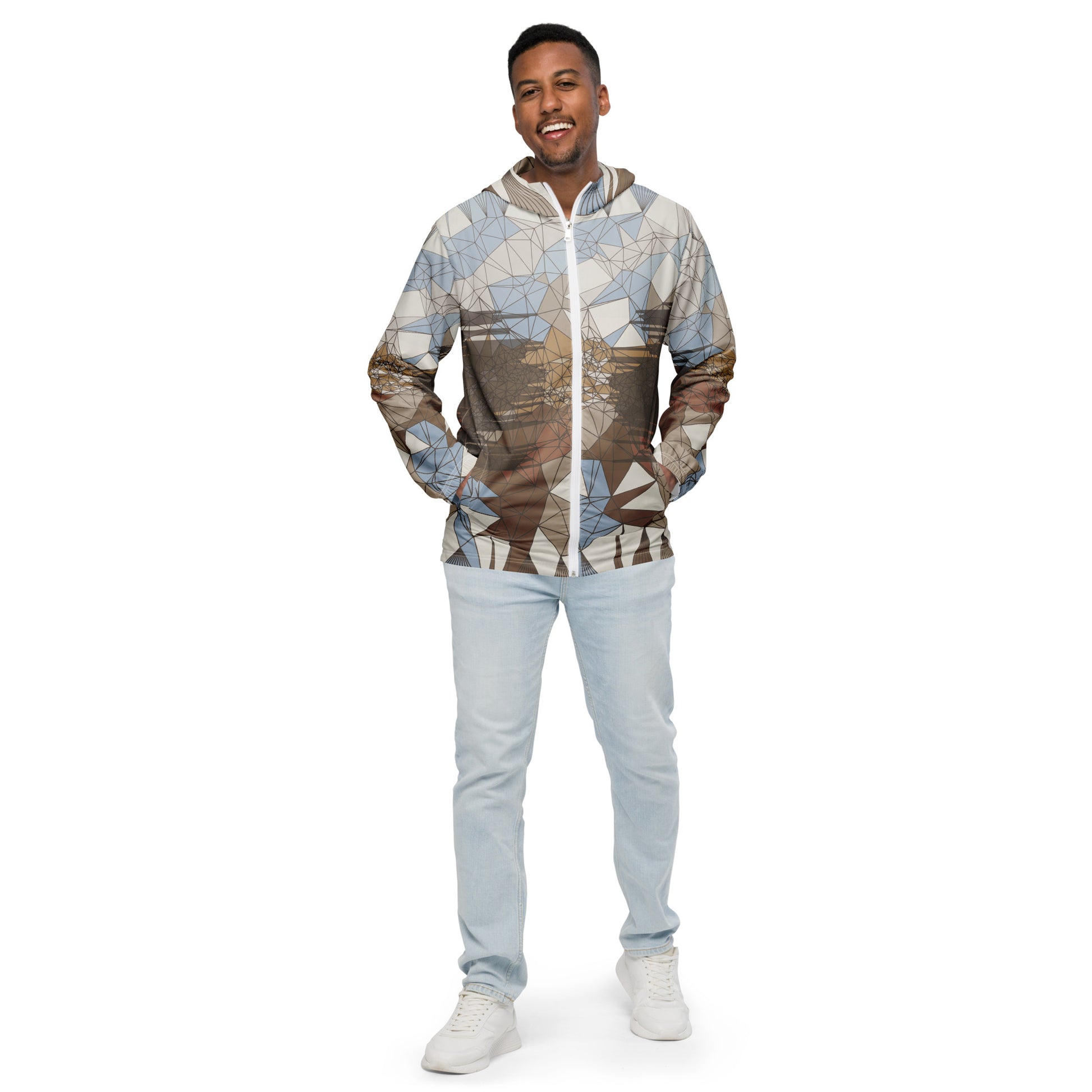 Man wearing a geometric patterned windbreaker and light blue jeans on a white background